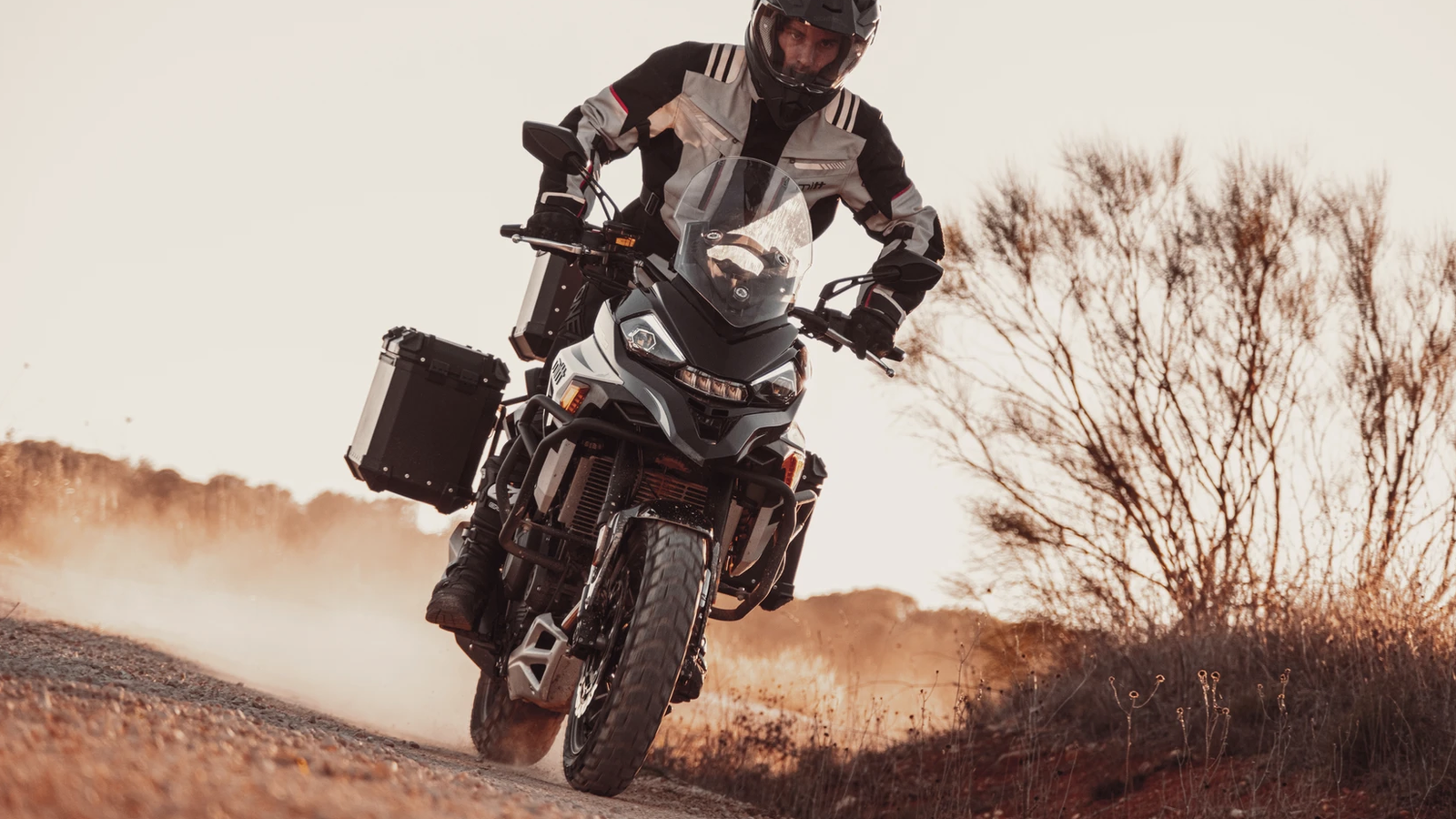 An adventure bike riding along a dirt track